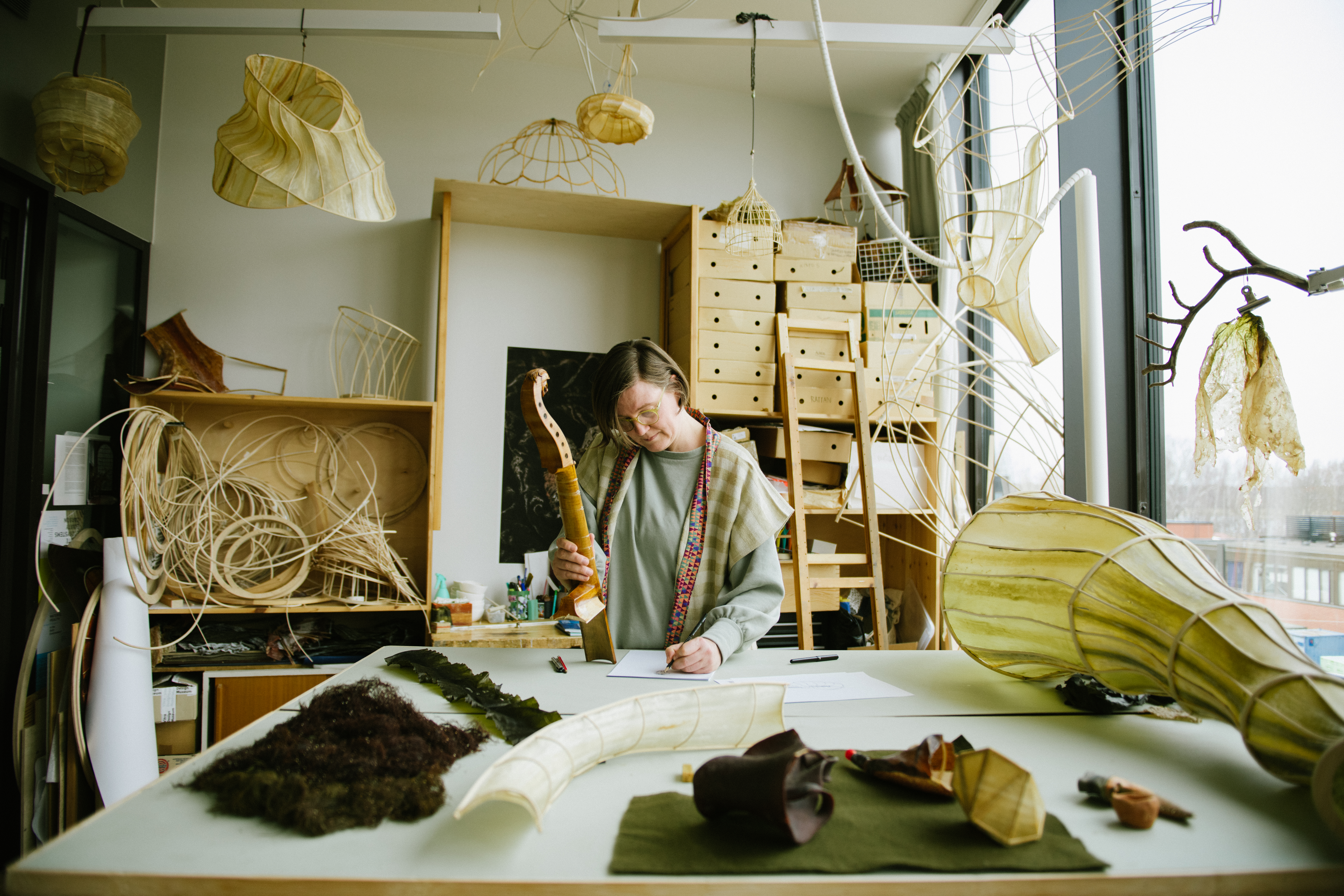Contemporary design professor, Julia Lohmann, working in her workshop filled with objects made from wood and seaweed.
